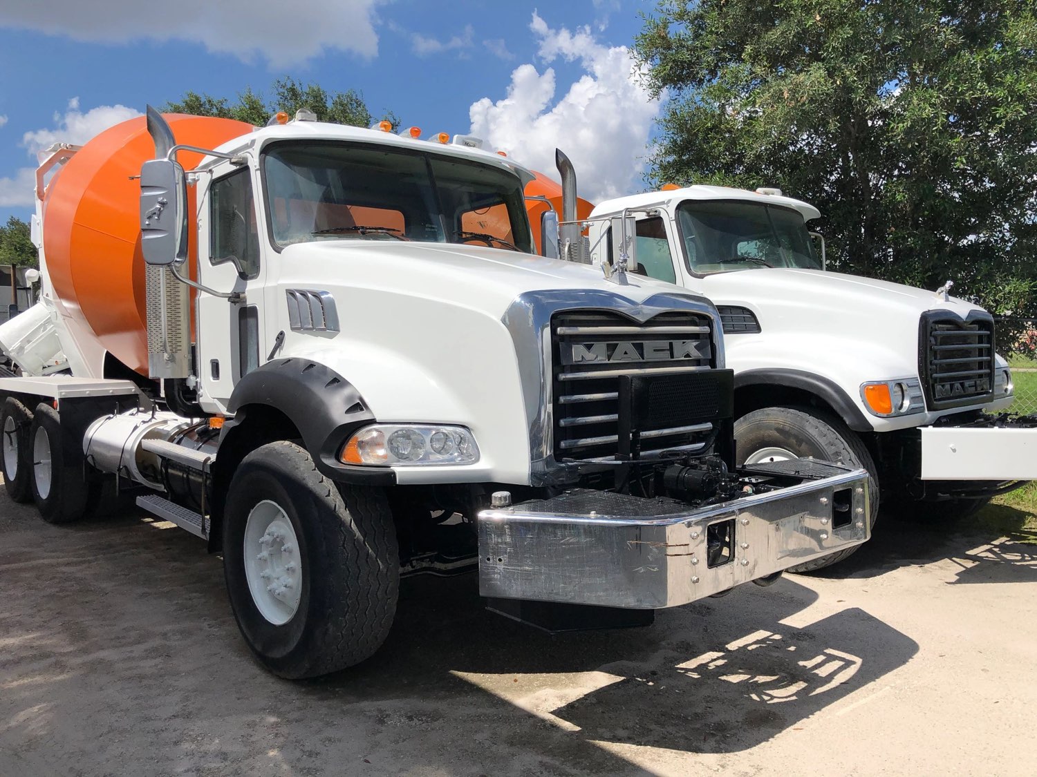 Two Mack mixer trucks with freshly painted orange drums on the SuperMixers yard